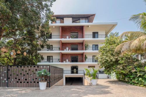 an apartment building with a fence and trees at G S Stay, 2BHK Luxury apartment Baga, Arpora, Goa in Arpora