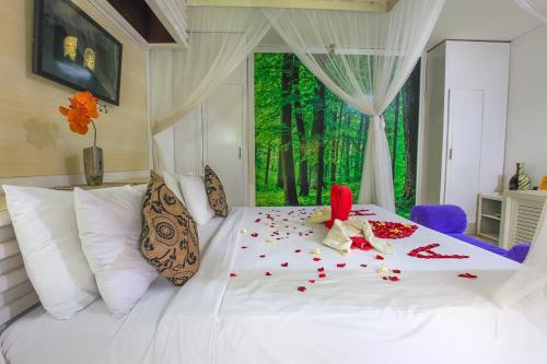 a bedroom with a white bed with confetti on it at Private Pool Villas Kuta Bali in Kuta