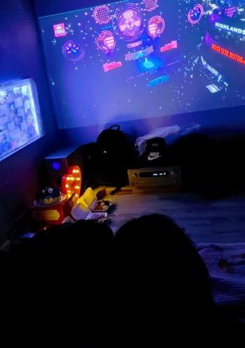 a dark room with a bed and a large tv at N'stay - Netfix Stay room- Cafe Film Netflix - Bar cafe & drinks 2424 in Hanoi