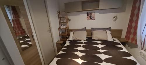 une chambre avec un lit avec une couette noire et blanche dans l'établissement ESTEREL le Montourey FRÉJUS, à Fréjus