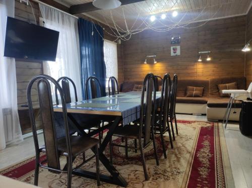 a dining room with a table and chairs and a couch at дом в Боровом Сарыбулак 4 комнатный in Vorobʼyëvka