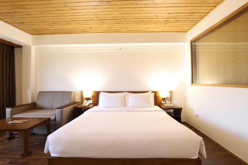 a hotel room with a bed and a couch at The Chumbi Mountain Retreat & Spa, A Club Mahindra Associate in Pelling