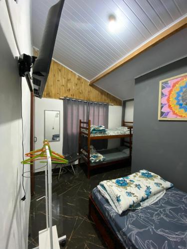 une chambre avec un lit et une chambre avec un lit superposé dans l'établissement Kitnet Girassol, à São Thomé das Letras