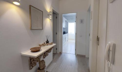 eine weiße Küche mit einem Tisch und einem Flur in der Unterkunft Casa AL Reis in Faro