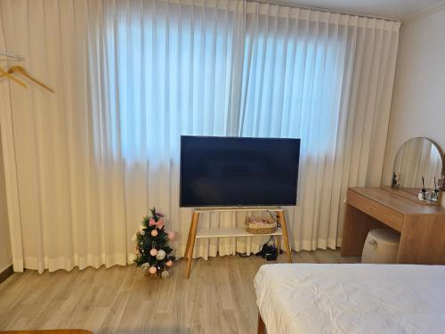 a bedroom with a television and a christmas tree in a room at Busan Subway 6min #2 Rooms #2 Queen Beds #Hotel Bedding #OTT #Table#1st Floor in Busan