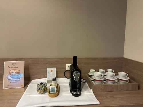 a table with a coffee maker and a tray of cups at JUFA Hotel Graz Süd - Self Check-in in Graz
