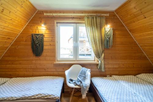 a room with two beds and a window at Maniówka - pokoje i domki w Bieszczadach in Maniów