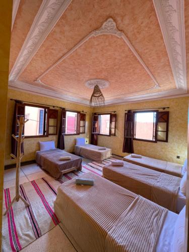a room with several beds in a room with windows at Berber Waves Surf House in Tamraght Ouzdar