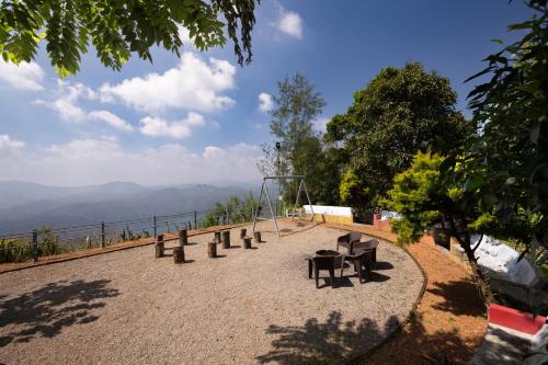 a park with benches and a swing on a hill at Avadale Idukki - Stag Groups Not Allowed in Idukki