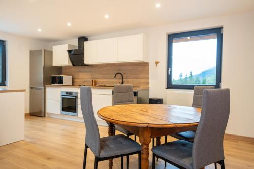 eine Küche und ein Esszimmer mit einem Holztisch und Stühlen in der Unterkunft Gîte pour 4 personnes - Le Grand Valtin, à 2 pas de Xonrupt in Ban-sur-Meurthe-Clefcy