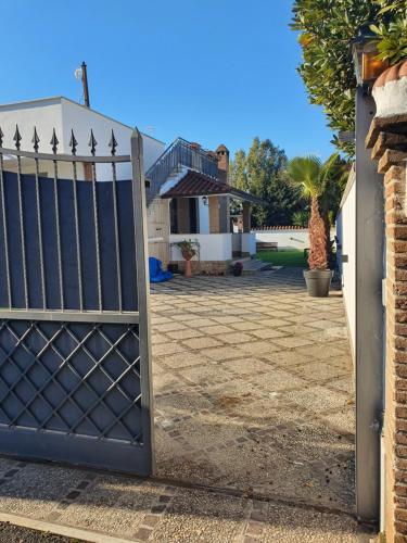 a gate in front of a house with a driveway at Il sole di Roma in Casal Palocco