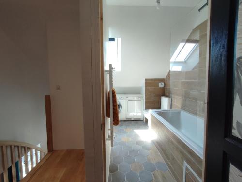une salle de bain avec baignoire dans une chambre dans l'établissement Ancienne école proche du Puy du Fou, à Montigné-sur-Moine