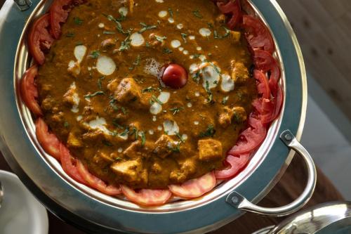 a pizza in a pan filled with sauce at Avadale Idukki - Stag Groups Not Allowed in Idukki