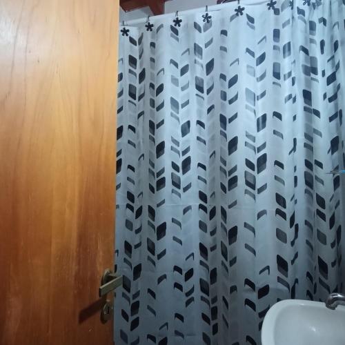 a bathroom with a shower curtain and a toilet at La Calandria in Villa Serranita