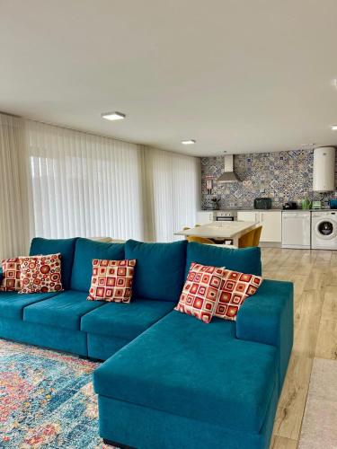 a blue couch in a living room with a kitchen at Quinta da Cachada in Lousada
