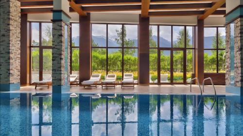 a pool with lounge chairs and a view of the mountains at TERRA Vista Penthouse near Pirin Golf and Bansko in Razlog