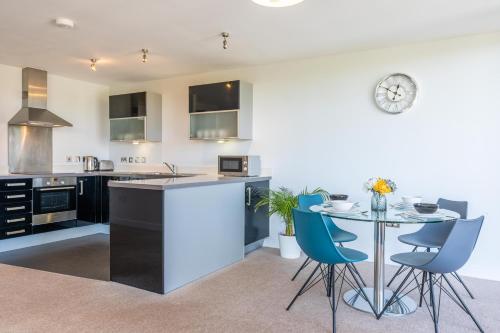 a kitchen and dining room with a table and chairs at Cotels at Vizion Serviced Apartments, Superfast Broadband, Central Location, Free Parking, Fully Equipped Kitchen in Milton Keynes