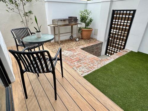 a patio with a table and chairs on a deck at Casa Montanari in Cape Town