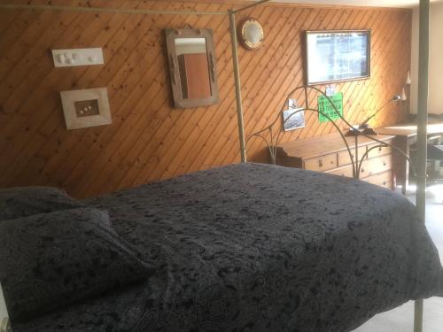 une chambre avec un lit et un mur en bois dans l'établissement La Cocadière, au Château-dʼOléron