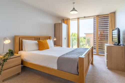 ein Schlafzimmer mit einem großen Bett und einem Fernseher in der Unterkunft Cotels at Vizion Serviced Apartments, Superfast Broadband, Central Location, Free Parking, Fully Equipped Kitchen in Milton Keynes