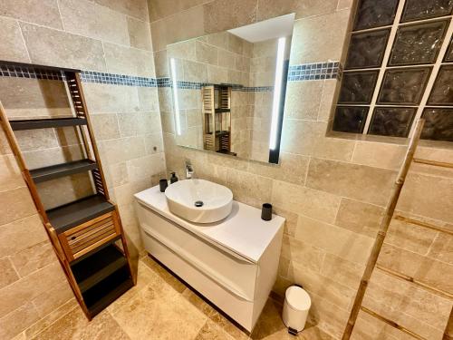 une salle de bain avec un lavabo blanc et un miroir dans l'établissement Mas de Baye - classé 5 étoiles meublé de tourisme, à Vaison-la-Romaine