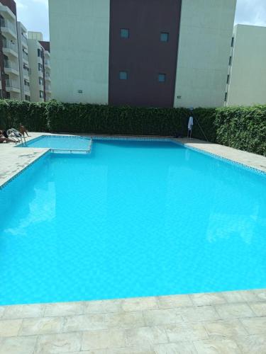 a large blue swimming pool in front of a building at Nanic Homes Executive Studio in Marimbeti