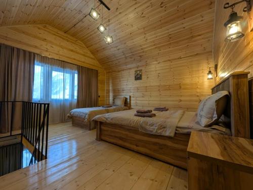 a bedroom with two beds in a wooden room at cottage nikolozi in Stepantsminda