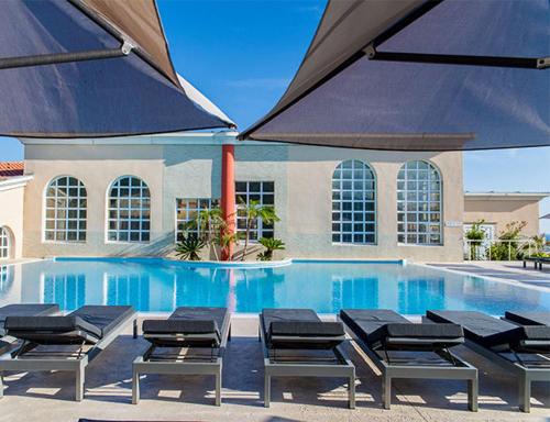 - une piscine avec un groupe de chaises à côté dans l'établissement Entre mer et montagne à BANYULS-SUR-MER, à Banyuls-sur-Mer