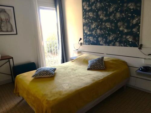 une chambre avec un lit avec deux oreillers dessus dans l'établissement Entre mer et montagne à BANYULS-SUR-MER, à Banyuls-sur-Mer