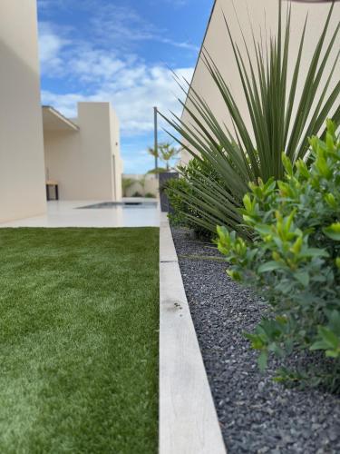 une maison avec une cour herbeuse à côté d'une maison dans l'établissement La villa Kalima T3, à Sérignan