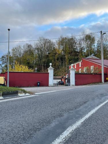 an empty street with a red fence and a red building at T2 au rez de chaussée dans propriété privée, au bord de l'eau à 15 minutes de Nancy in Toul