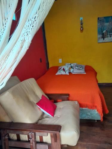 a bedroom with a bed and a couch in it at Cábañas el Descanso in Mar del Plata