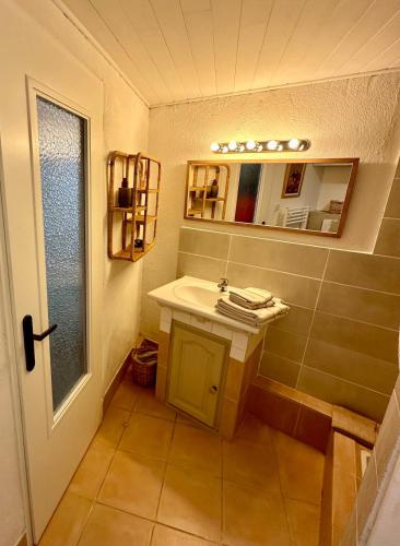 une salle de bain avec un lavabo et un miroir dans l'établissement Charmante Maison de Village, Saint remy de provence, à Saint-Rémy-de-Provence