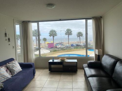 a living room with a couch and a large window at First line, ocean view in Coquimbo