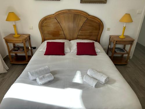 - un grand lit blanc avec 2 oreillers rouges dans l'établissement Grande maison de village, à Olmeto