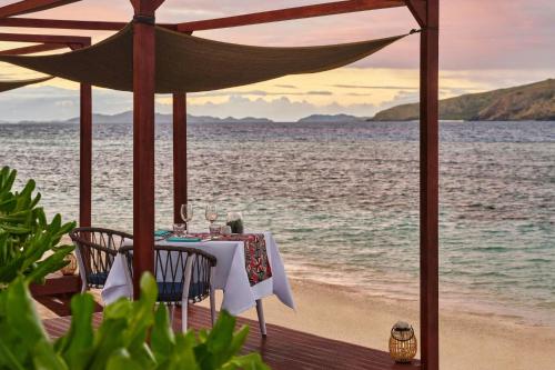 a table and chairs on the beach with the ocean at Sheraton Resort & Spa, Tokoriki Island, Fiji in Tokoriki