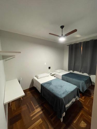 a bedroom with two beds and a ceiling fan at Hotel Silver in Rio das Pedras