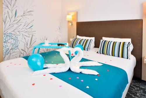 two people laying on a bed in a hotel room at Hotel Lille Europe in Lille