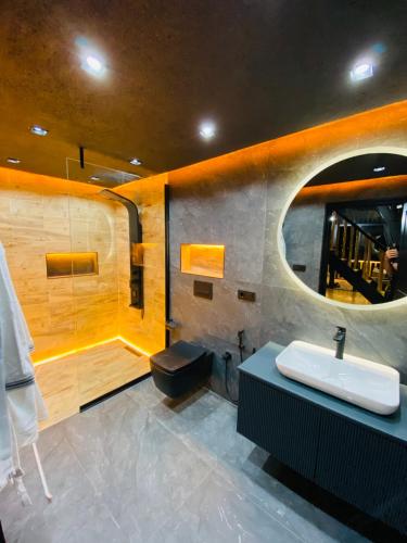 a bathroom with a sink and a mirror at Vadiyebak Suit Bungalov in Ardeşen