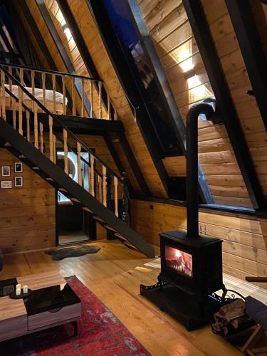 a wood stove in a room with a staircase at Vadiyebak Suit Bungalov in Akkaya