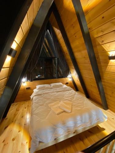 a bed in the attic of a wooden cabin at Vadiyebak Suit Bungalov in Akkaya