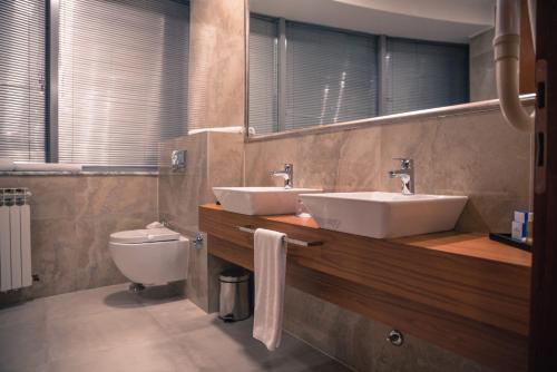 a bathroom with two sinks and a toilet at Radon Plaza in Sarajevo