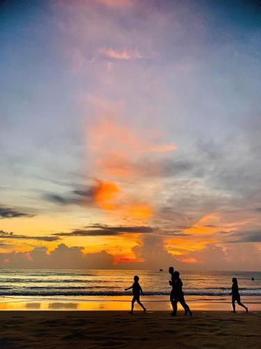 a group of people running on the beach at sunset at Huy Hoàng Hotel in Xóm Cầu Hin
