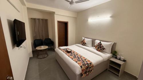a hotel room with a bed and a television at Hotel Ivaan Homes opposite to Iskcon Temple East of Kailash New Delhi in New Delhi