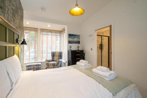 a bedroom with a large bed with towels on it at Hale House, Leiston - Aldeburgh Coastal Cottages in Leiston