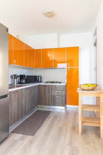 a kitchen with orange and white cabinets and a table at Il Giardino Di Lory in Vercana