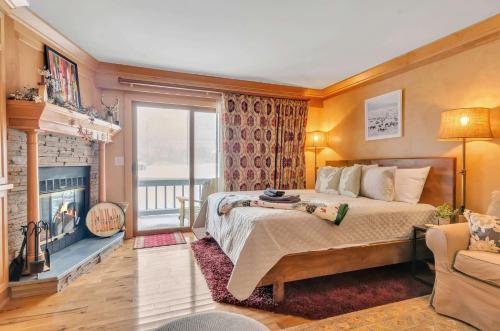 a bedroom with a large bed and a fireplace at Cozy Studio Wood Fireplace in Ellicottville