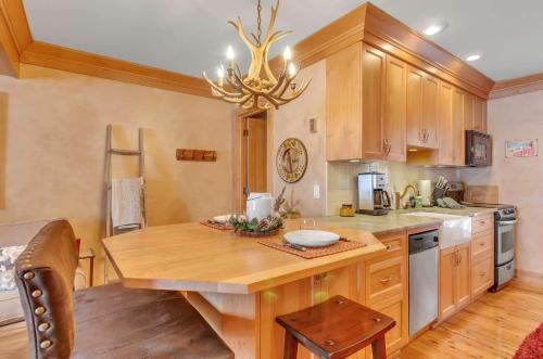 a kitchen with a wooden table and a chandelier at Cozy Studio Wood Fireplace in Ellicottville