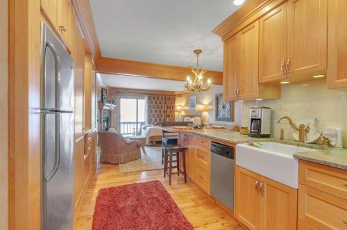 a kitchen with wooden cabinets and stainless steel appliances at Cozy Studio Wood Fireplace in Ellicottville