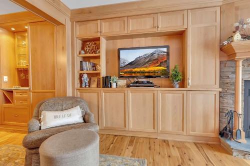 a living room with a tv and a chair at Cozy Studio Wood Fireplace in Ellicottville